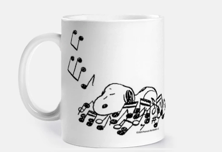 Cup snoopy sleeping on music